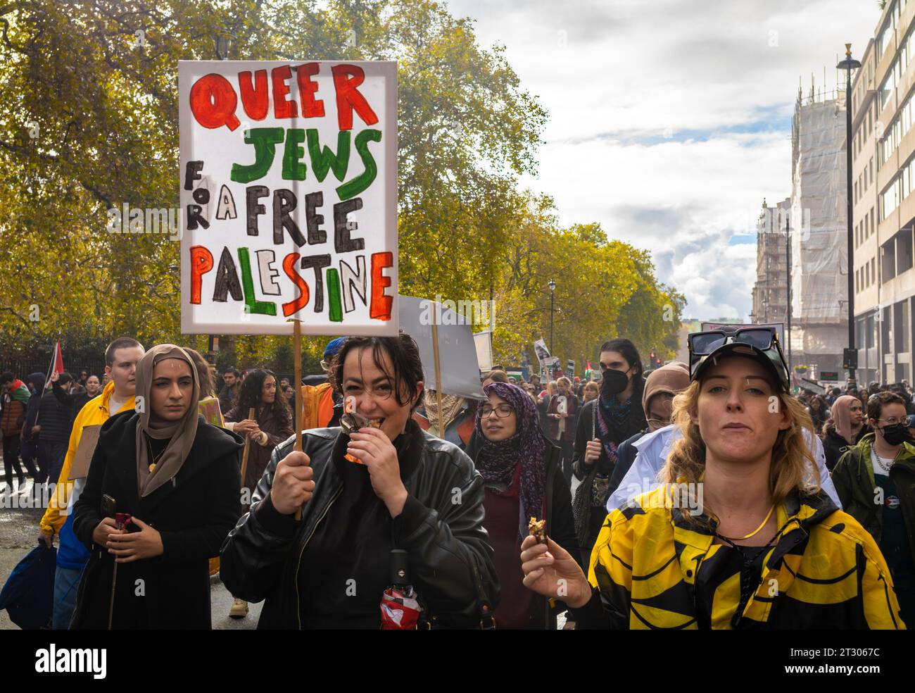 London, Großbritannien. 21. Oktober 2023: Eine Frau mit einem Plakat mit der Aufschrift „Queer Jews for a Free Palestine“ marschiert mit anderen pro-palästinensischen Demonstranten bei einer großen Demonstration gegen israelische Angriffe auf Gaza im Zentrum von London. Stockfoto