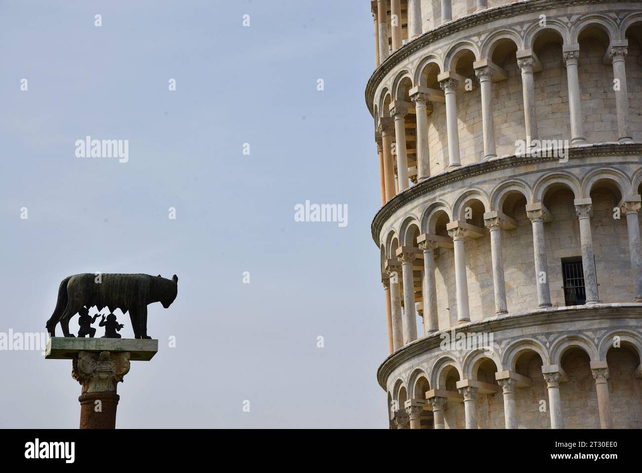 Pisa, Italien. September 2023. Statue von Romulus und Remus, die den Wolf Capitolina vor einem Abschnitt des Schiefen Turms säugen. Stockfoto