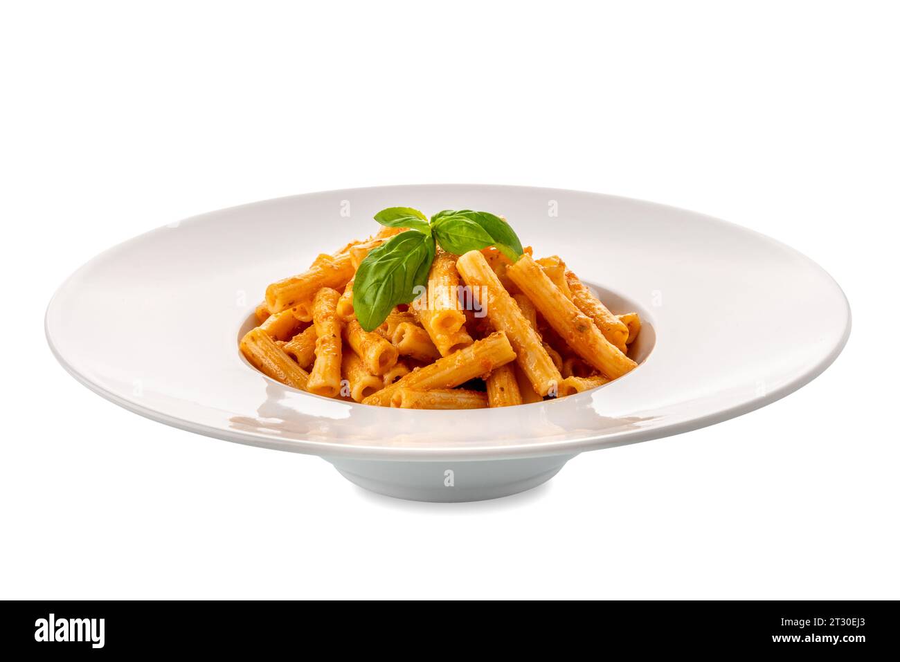 Macaroni Rigati Nudeln mit Tomatensauce. Italienische Pasta namens Sedani rigati (gestreifter Sellerie) mit Tomatenpesto und Basilikumblättern in weißer Schale isoliert Stockfoto