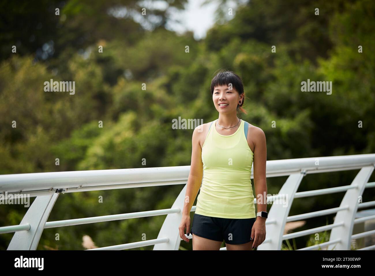 Außenporträt einer glücklichen jungen asiatischen Sportlerin Stockfoto