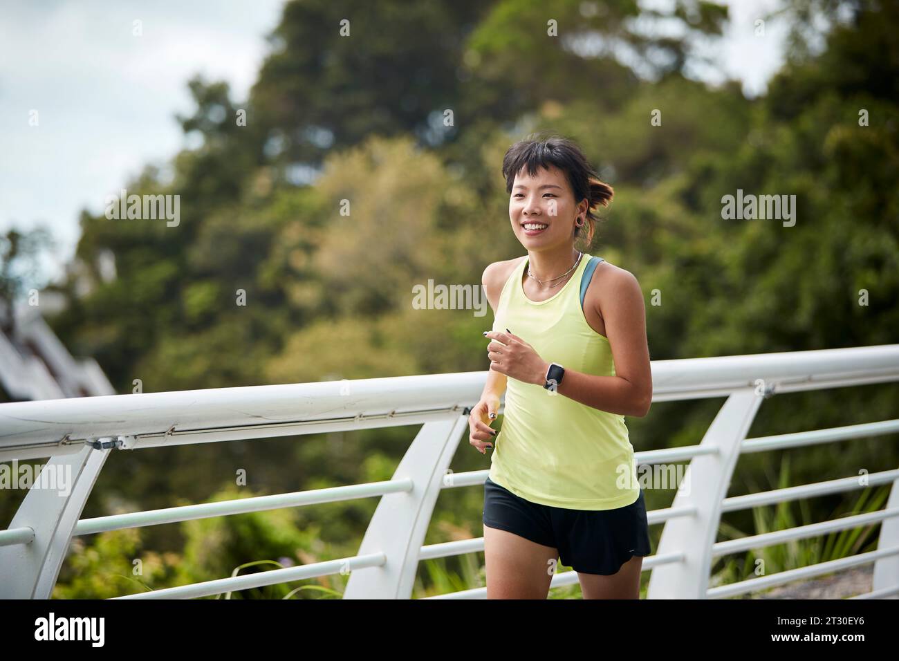 Junge asiatische Frau, die im Stadtpark Joggen läuft Stockfoto