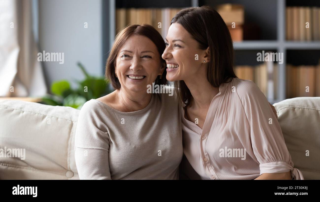 Erwachsene Tochter und ältere Mutter lachen sich an vergangene lustige Geschichten Stockfoto