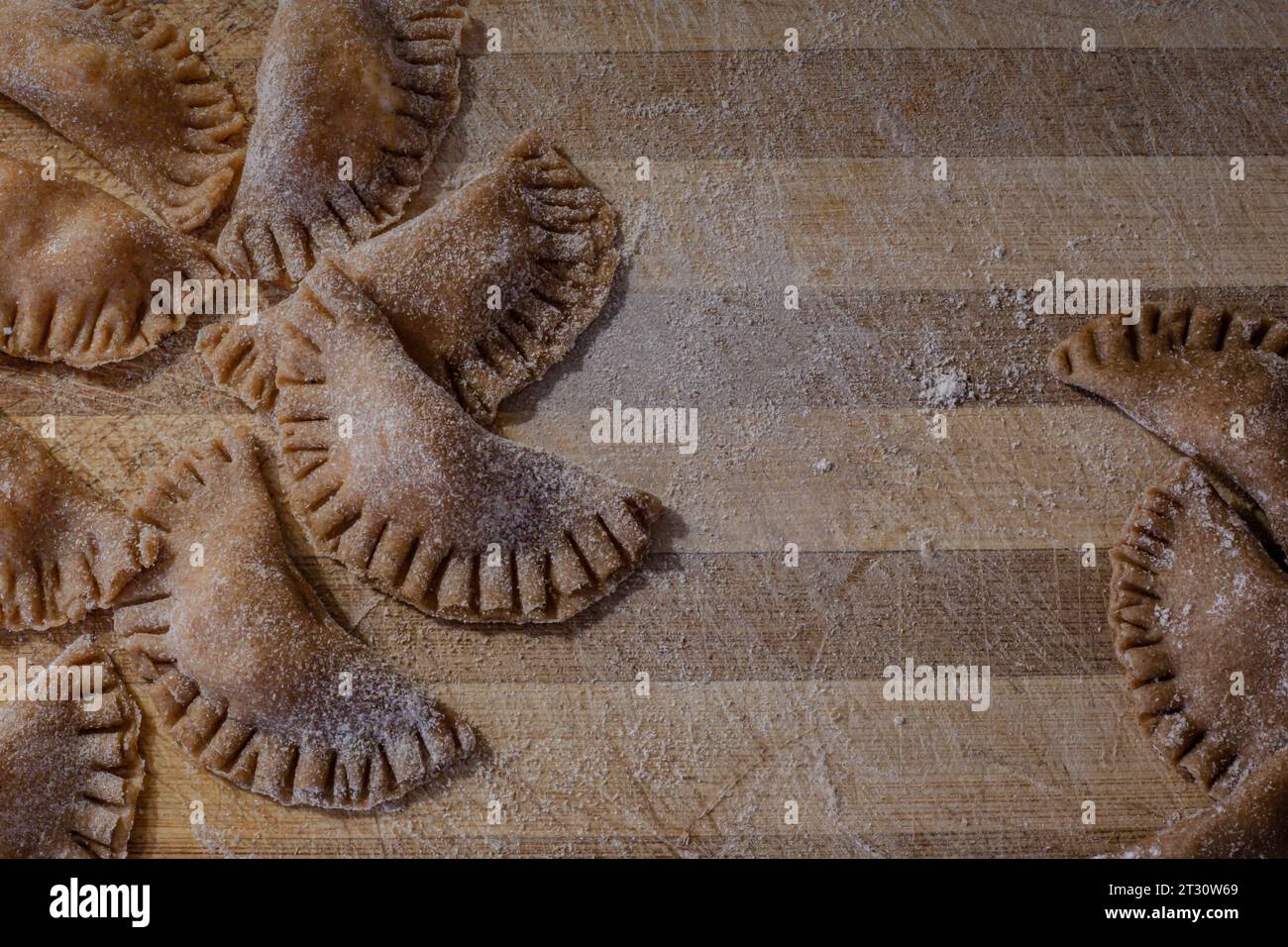 Traditionelle italienische Ravioli. Hausgemachte italienische Pasta. Frische Ravioli auf Holzbrett, Blick von oben Stockfoto