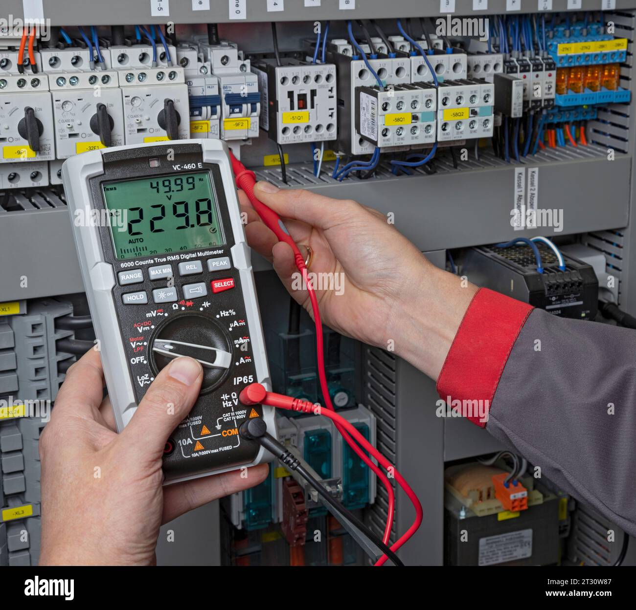 Elektriker, der mit einem Multimeter in einem Schaltschrank misst Stockfoto