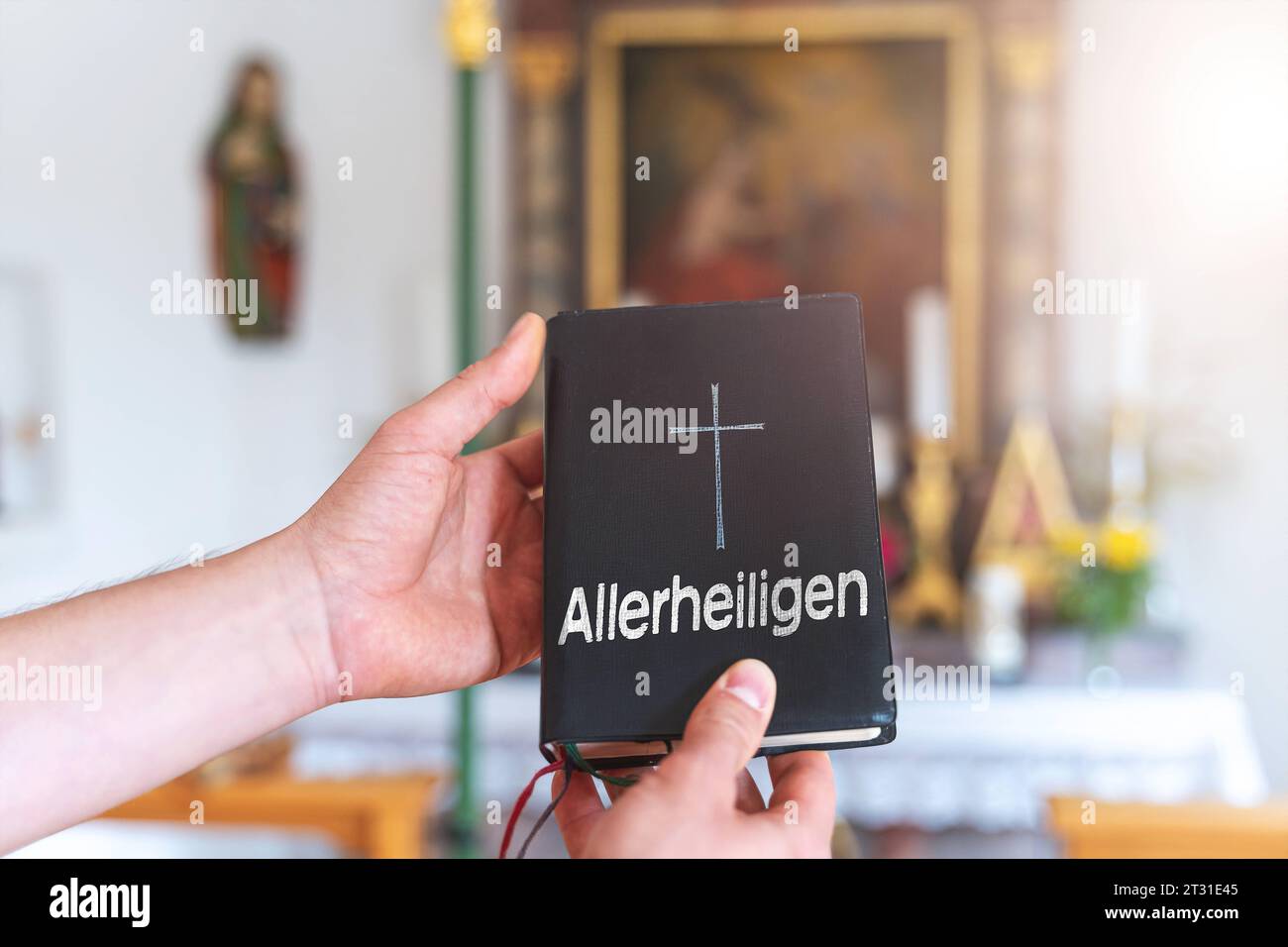 22. Oktober 2023: Ein Mann, der ein Buch in einer Kirche mit einem Kreuz hält und die Inschrift Allerheiligen-Tag-FOTOMONTAGE *** ein Mann hält in einer Kirche ein Buch in der Hand mit einem Kreuz und der Aufschrift Allerheiligen FOTOMONTAGE Credit: Imago/Alamy Live News Stockfoto