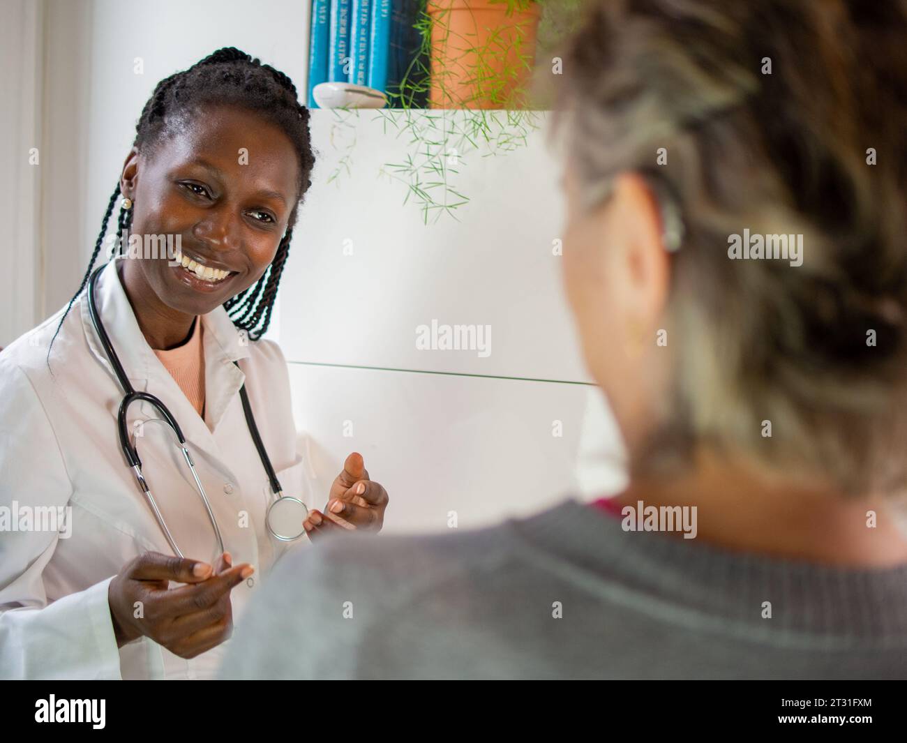 Eine junge Ärztin, die bereit ist, ein Stethoskop mit ihrem Patienten zu benutzen Stockfoto Eine junge Ärztin, die bereit ist, ein Stethoskop mit ihrem Patienten zu benutzen Stockfoto