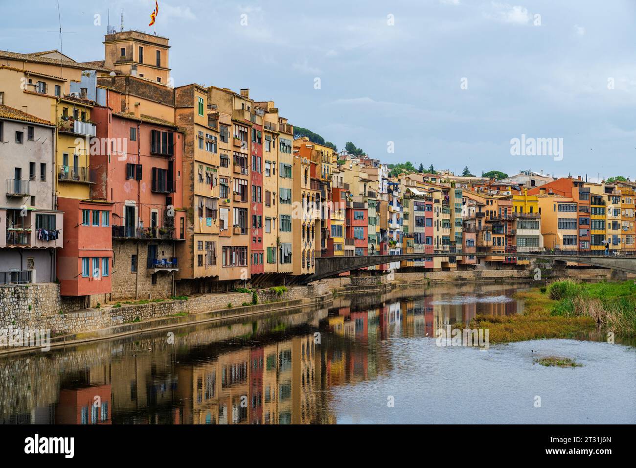 Ein Foto von hell bemalten Häusern und ihren Reflexionen im Fluss Onyar in Gerona, Spanien Stockfoto