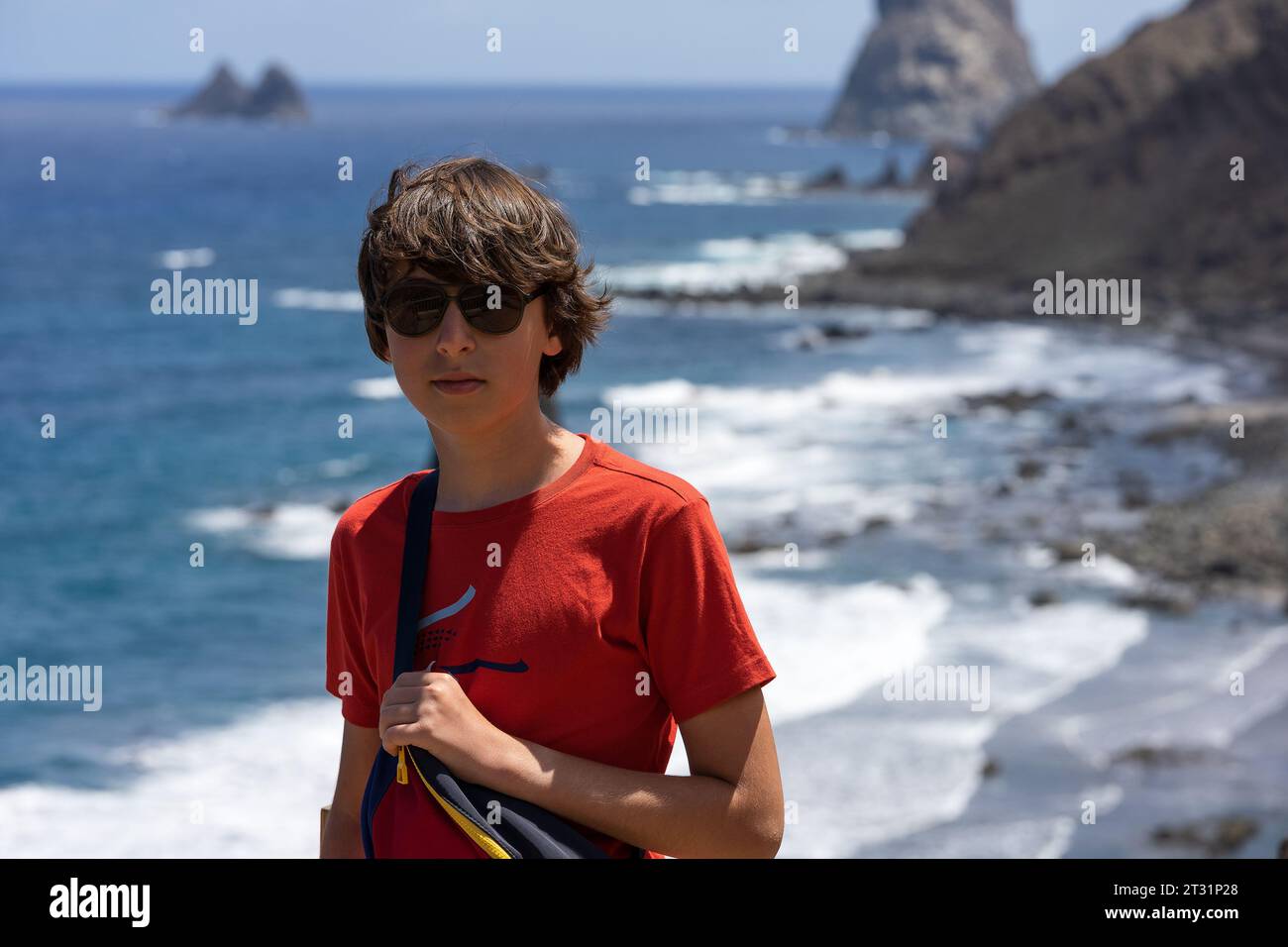 Porträt eines Teenagers vor der felsigen Küste des Atlantiks. Aussichtspunkt - Mirador Playa de Benijo, Teneriffa. Kanarische Inseln. Spanien. Stockfoto