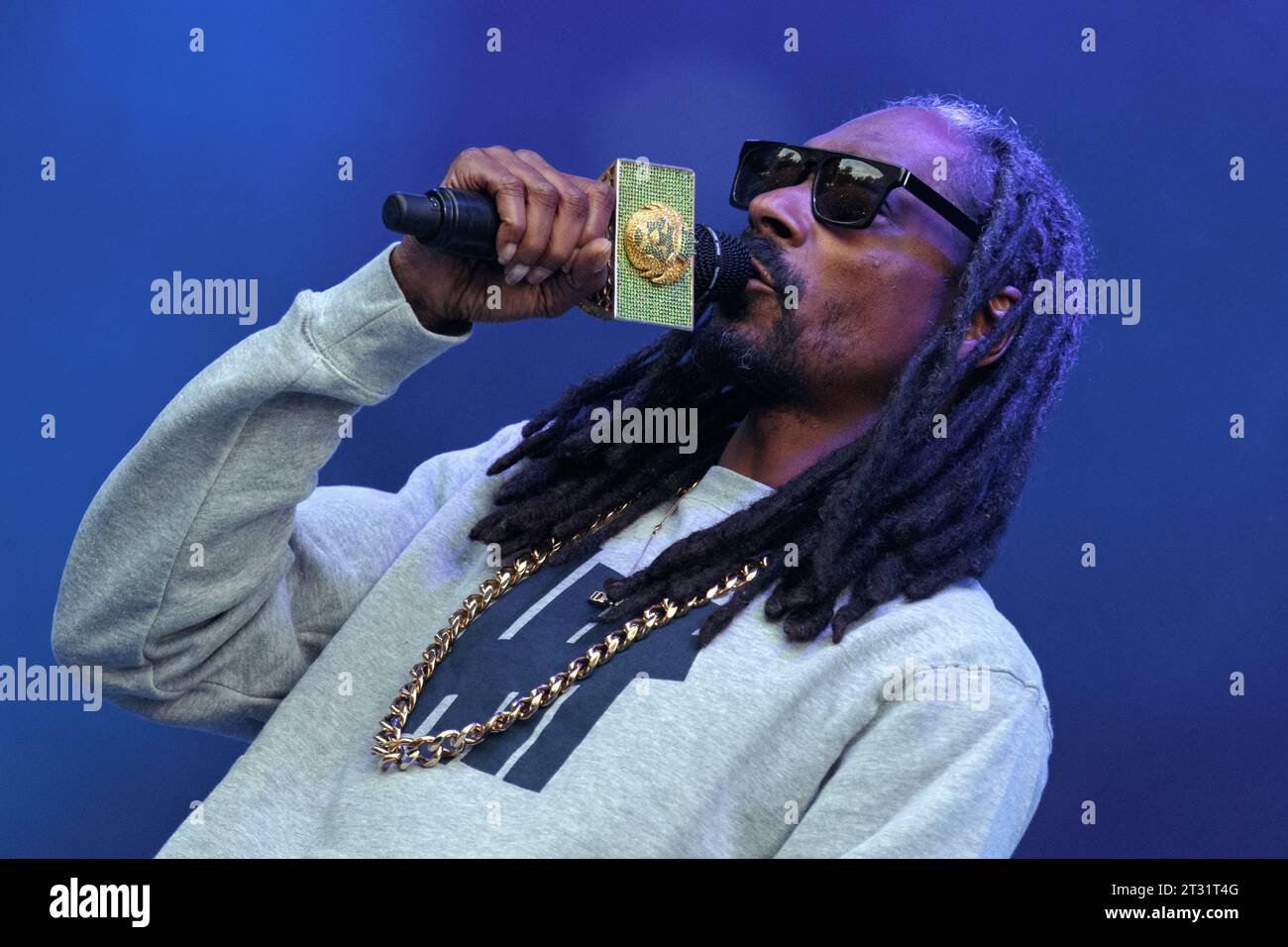 Snoop Dogg tritt live auf der Bühne mit einem goldenen Mikrofon auf. Stockfoto