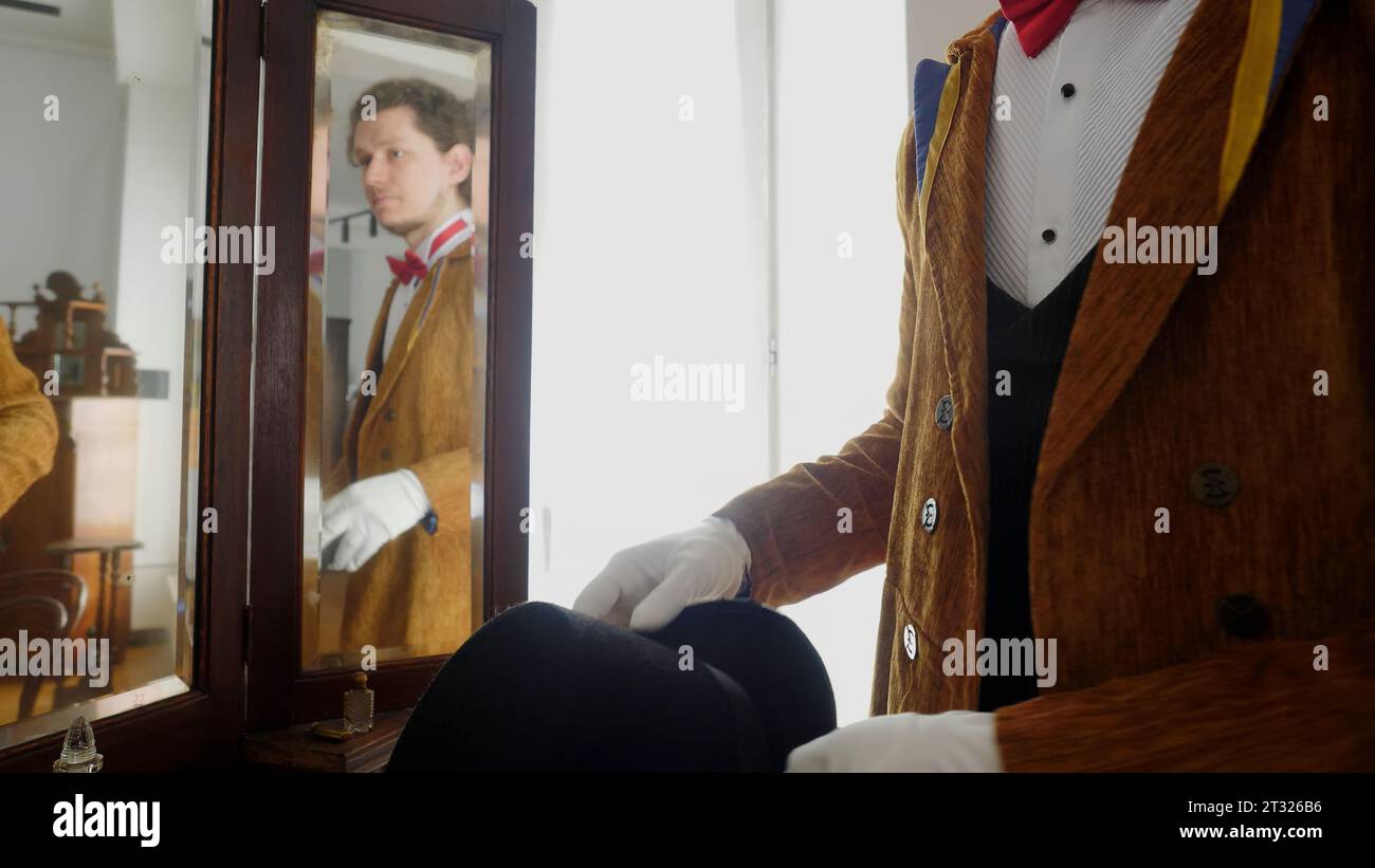 Der Mann ist ein Zauberer. Archivmaterial. Ein junger Schauspieler in braunem Anzug mit Hut, der der Aufführung zugeteilt wird. Stockfoto