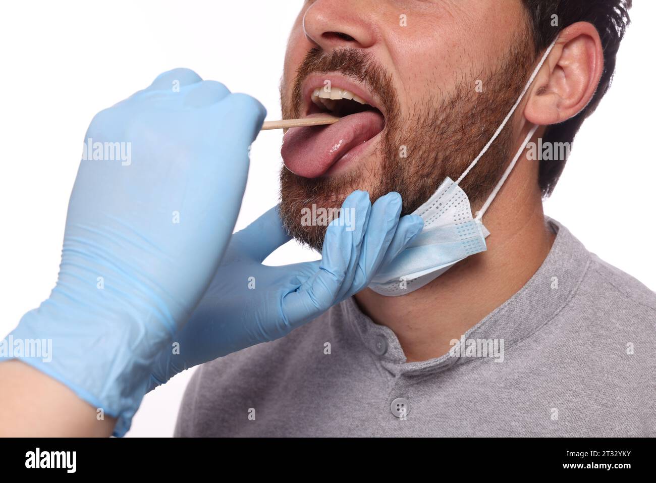 Arzt untersucht die Mundhöhle des Mannes mit Zungendepressor auf weißem Hintergrund, Nahaufnahme Stockfoto