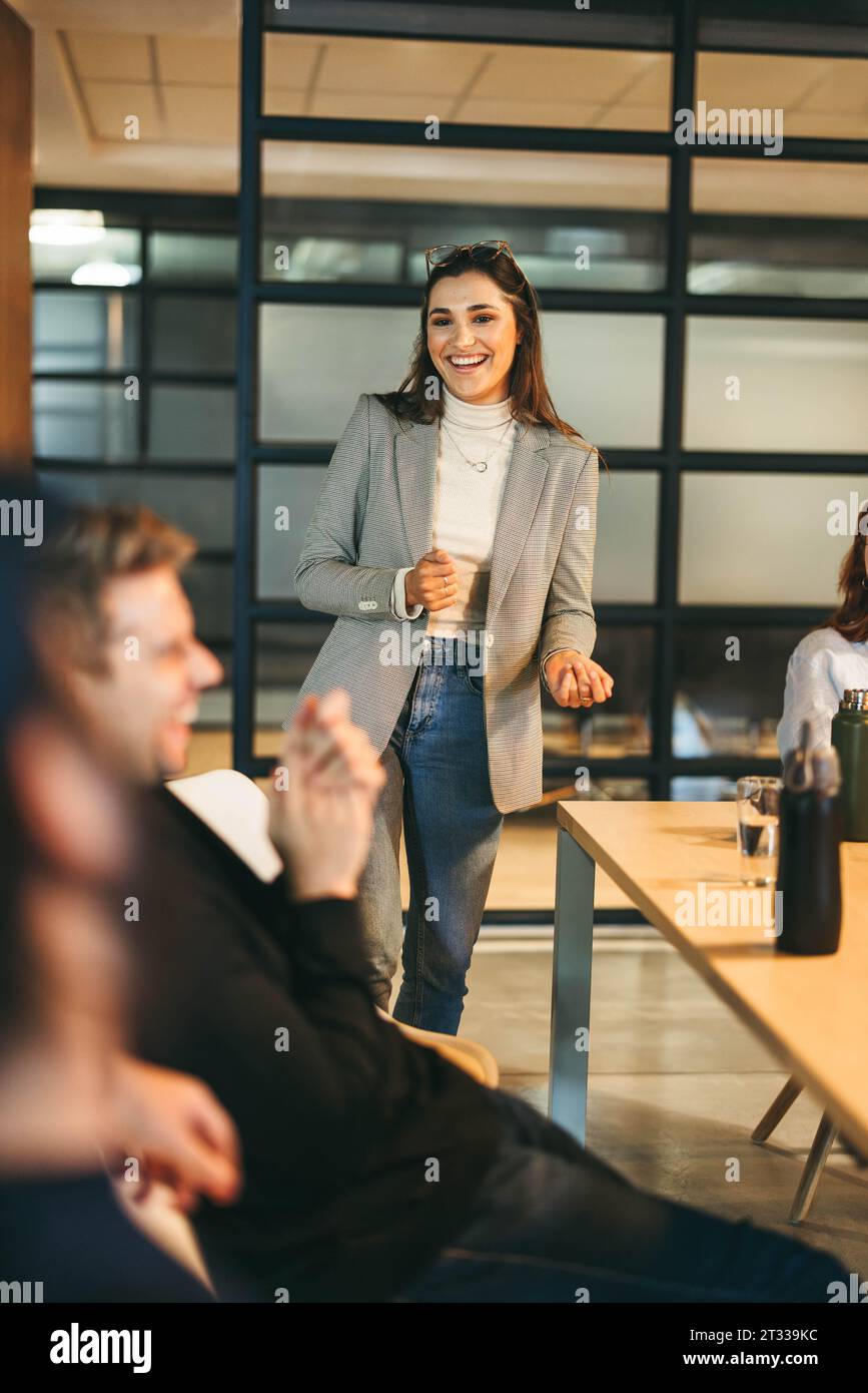 Glückliche Geschäftsleute in einem modernen Büro nehmen an einem lebhaften Brainstorming-Meeting Teil. Mit einem Schwerpunkt auf Kreativität und Teamarbeit diskutieren sie Projektmana Stockfoto