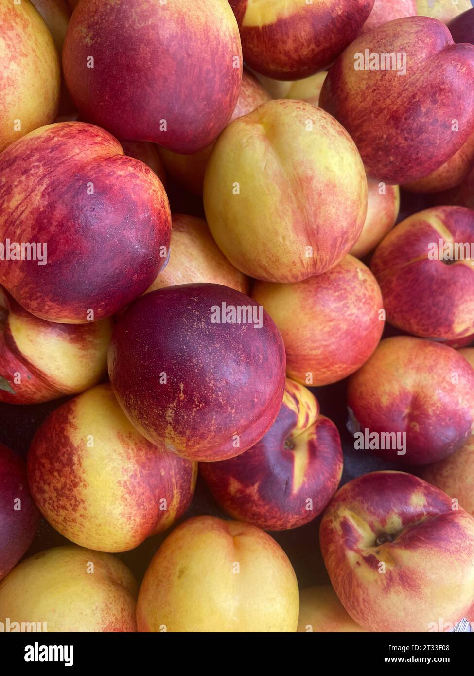 Pile of Georgia Peaches in einem Lebensmittelgeschäft mit Lebensmittelhintergrund Stockfoto