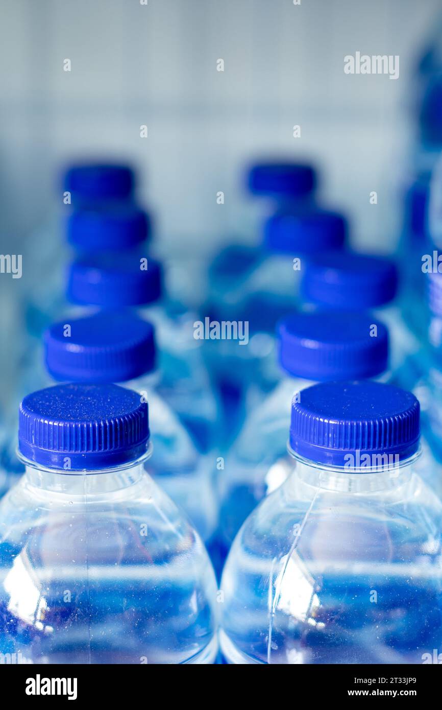 Mineralwasserflaschen in einer Reihe mit blauen Kappen Stockfoto
