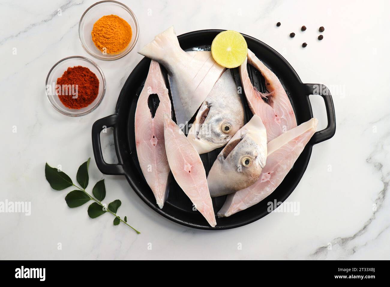 Frischer ganzer Silver Pomfret Fisch oder Butterfisch oder Poplet in Scheiben geschnitten. Gereinigt und bereit zum Frittieren zusammen mit Gewürzen. Zutaten und Rezept Stockfoto