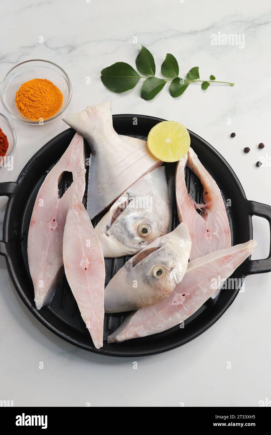 Frischer ganzer Silver Pomfret Fisch oder Butterfisch oder Poplet in Scheiben geschnitten. Gereinigt und bereit zum Frittieren zusammen mit Gewürzen. Zutaten und Rezept Stockfoto