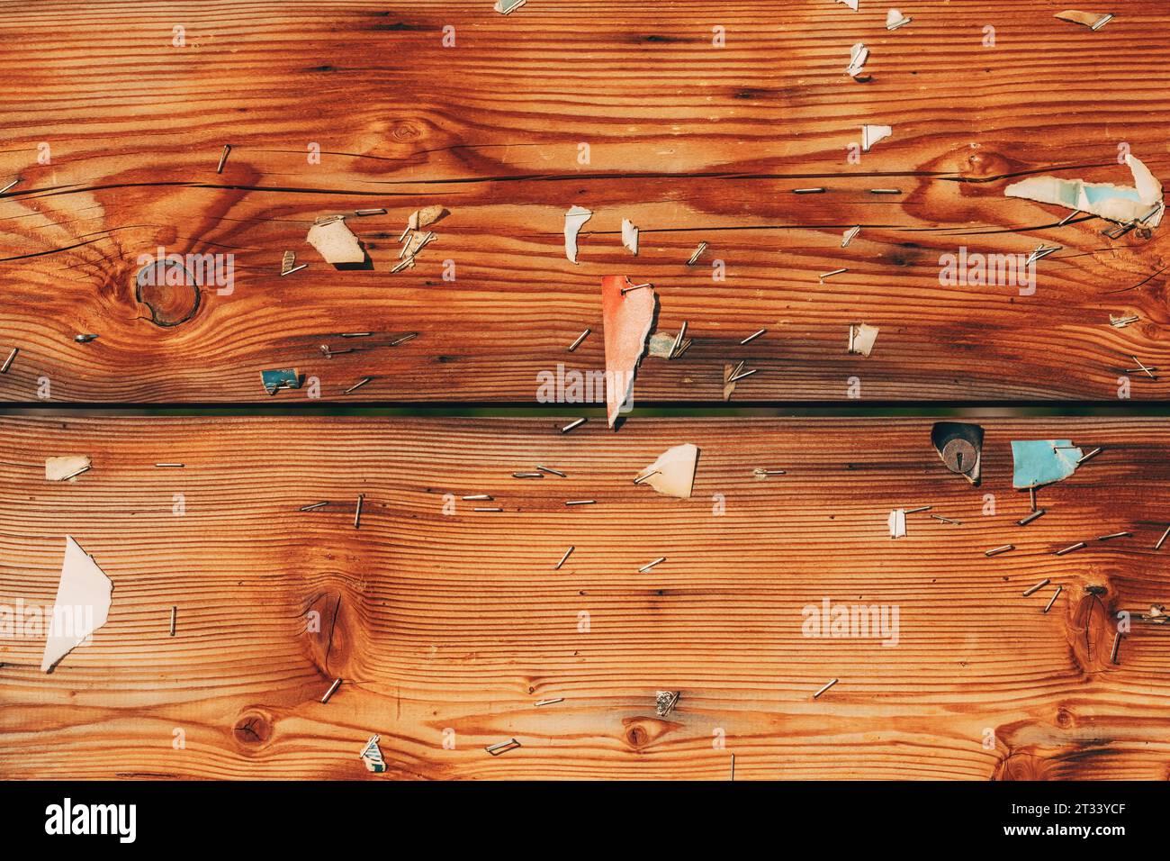 Abgenutztes Holzbrett mit Papier und Heftklammernmunition als Hintergrund Stockfoto