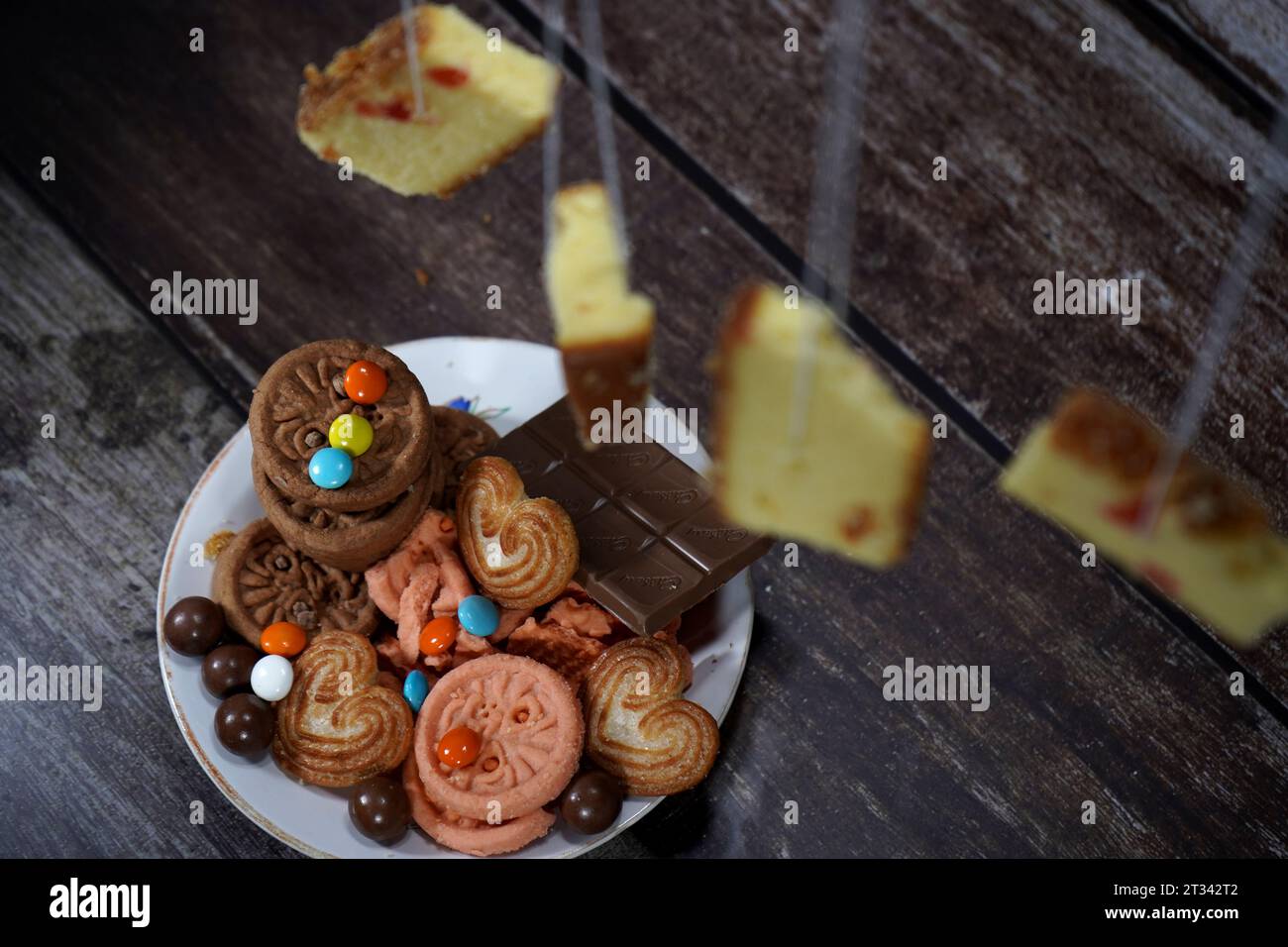 Einige Creme-Kekse, Kekse, Schokoladenkuchen werden auf einen Teller gelegt Stockfoto