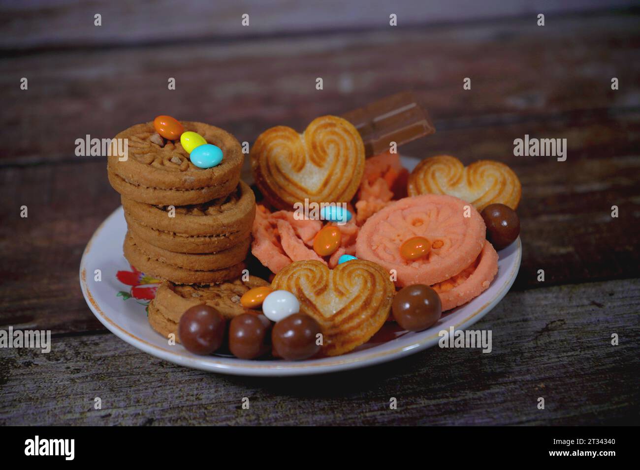 Einige Creme-Kekse, Kekse, Schokoladenkuchen werden auf einen Teller gelegt Stockfoto
