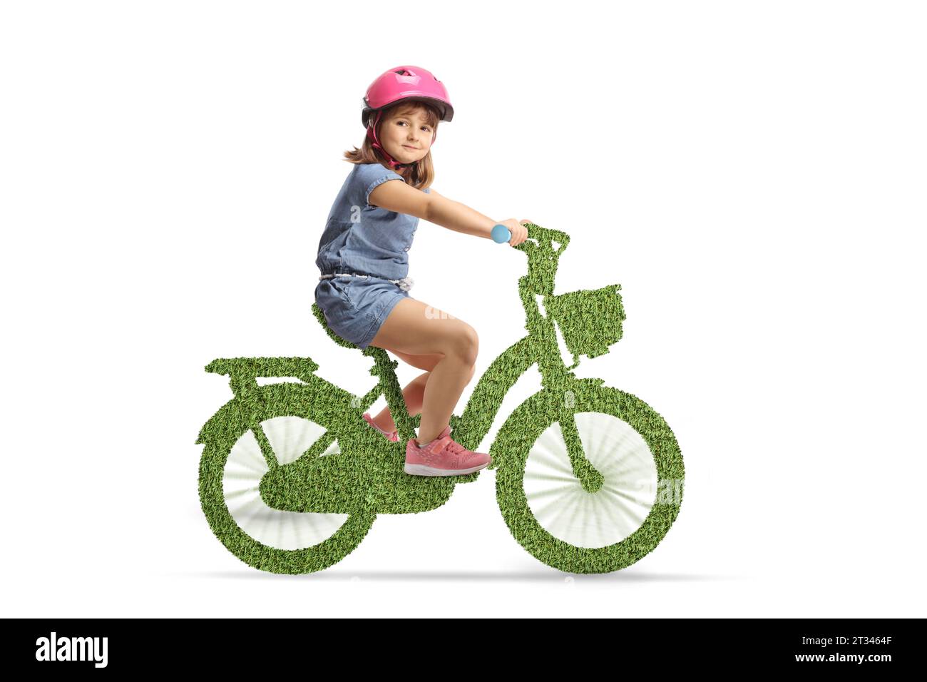 Mädchen, das mit einem Helm auf einem grünen Öko-Fahrrad fährt und die Kamera auf weißem Hintergrund betrachtet Stockfoto