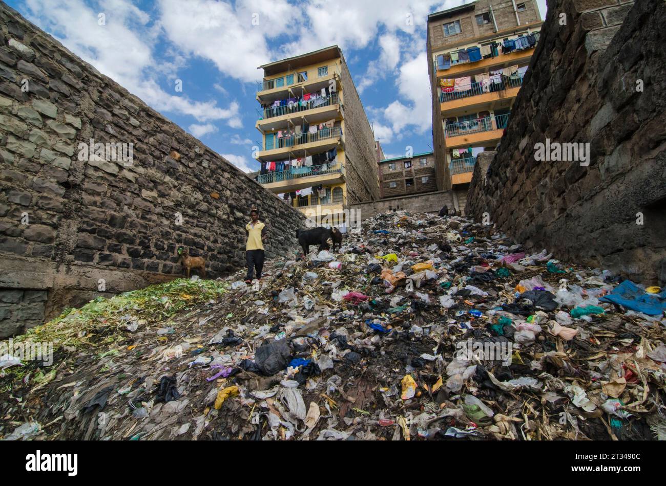 Eine kenianische Frau läuft durch Einen riesigen Müllhaufen im Urban Slum von Mathare, Nairobi, Kenia Stockfoto