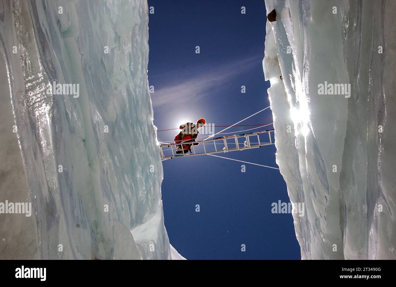 Ngawang Sherpa überquert eine riesige Spalte auf einer Leiter Stockfoto