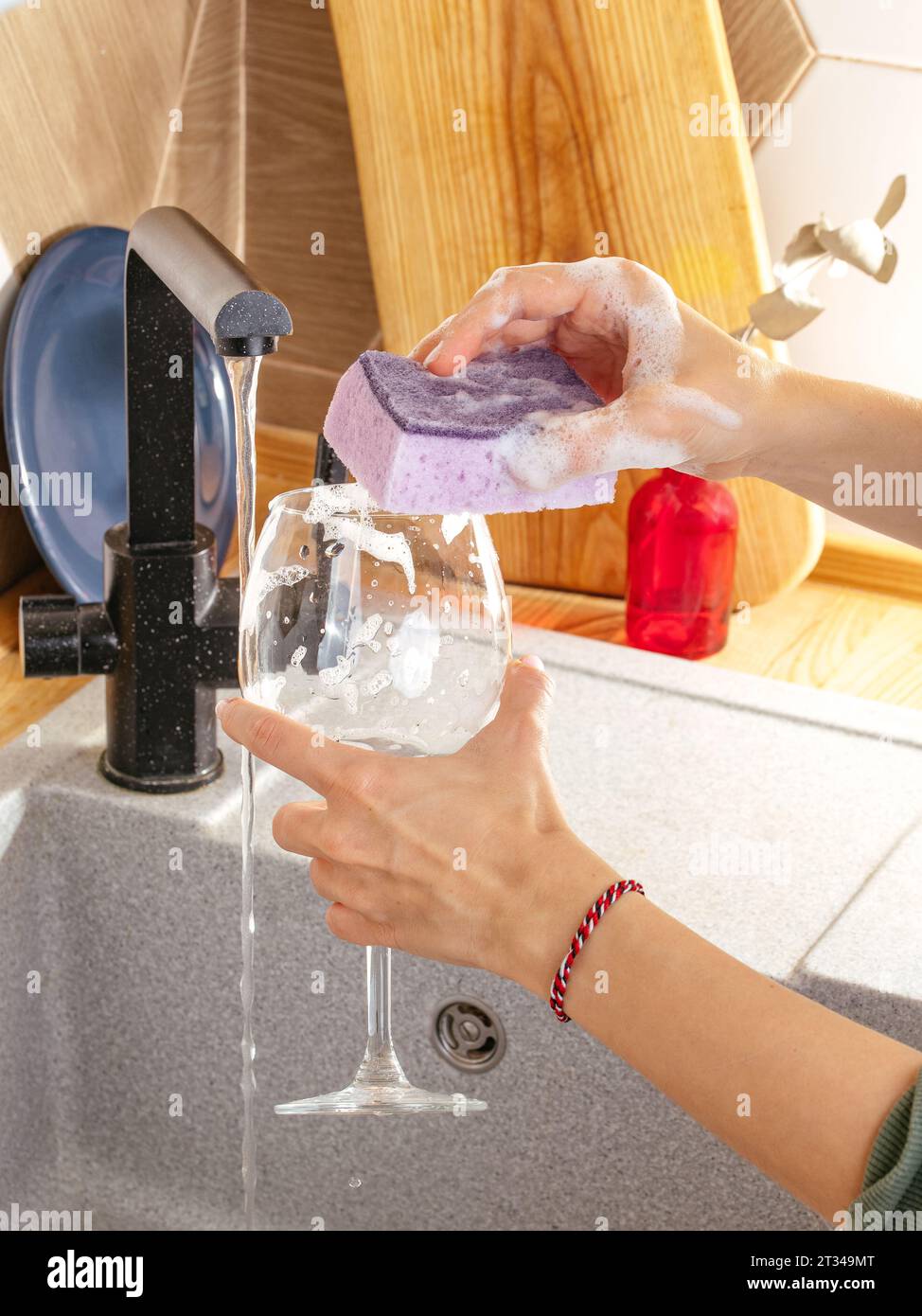 Ein Mädchen wäscht ein Weinglas Stockfoto