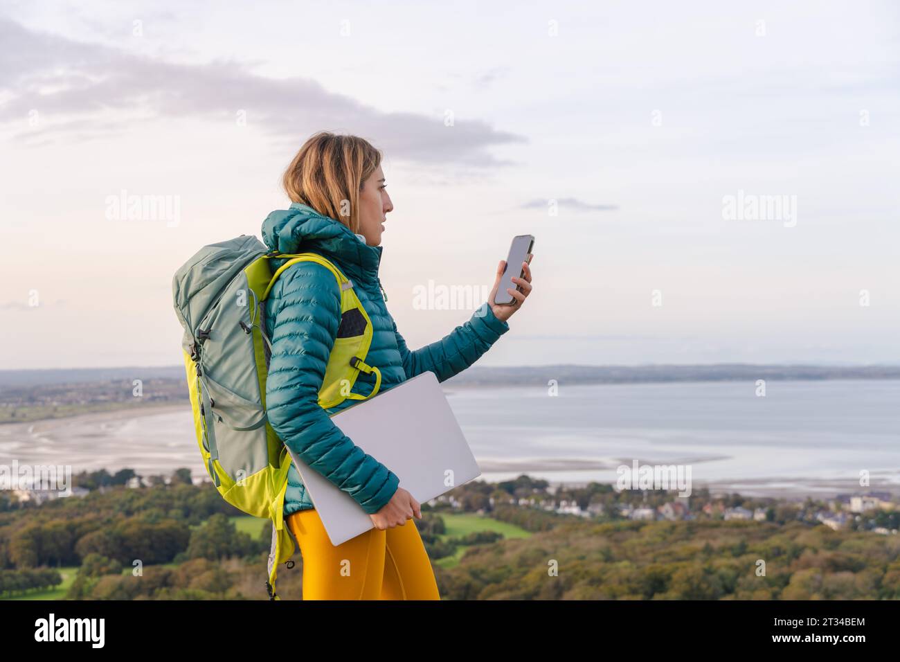 Digital Nomad freischaffende Frau mit Handy und Laptop Stockfoto