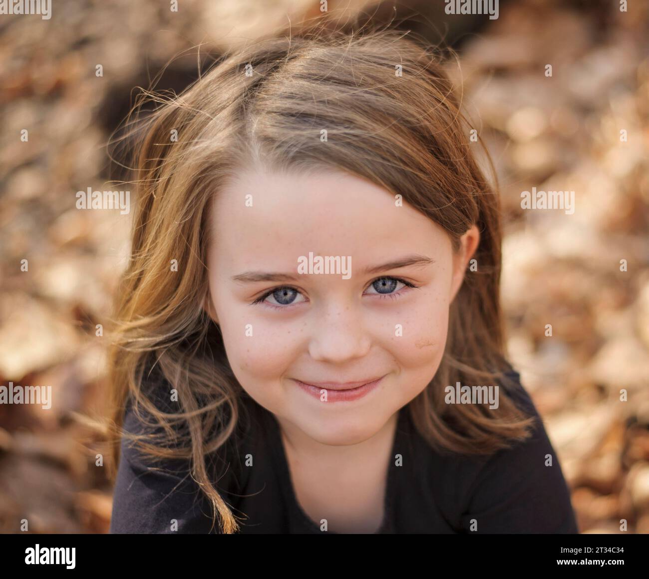 Glückliches kleines Mädchen, das draußen lächelt Stockfoto