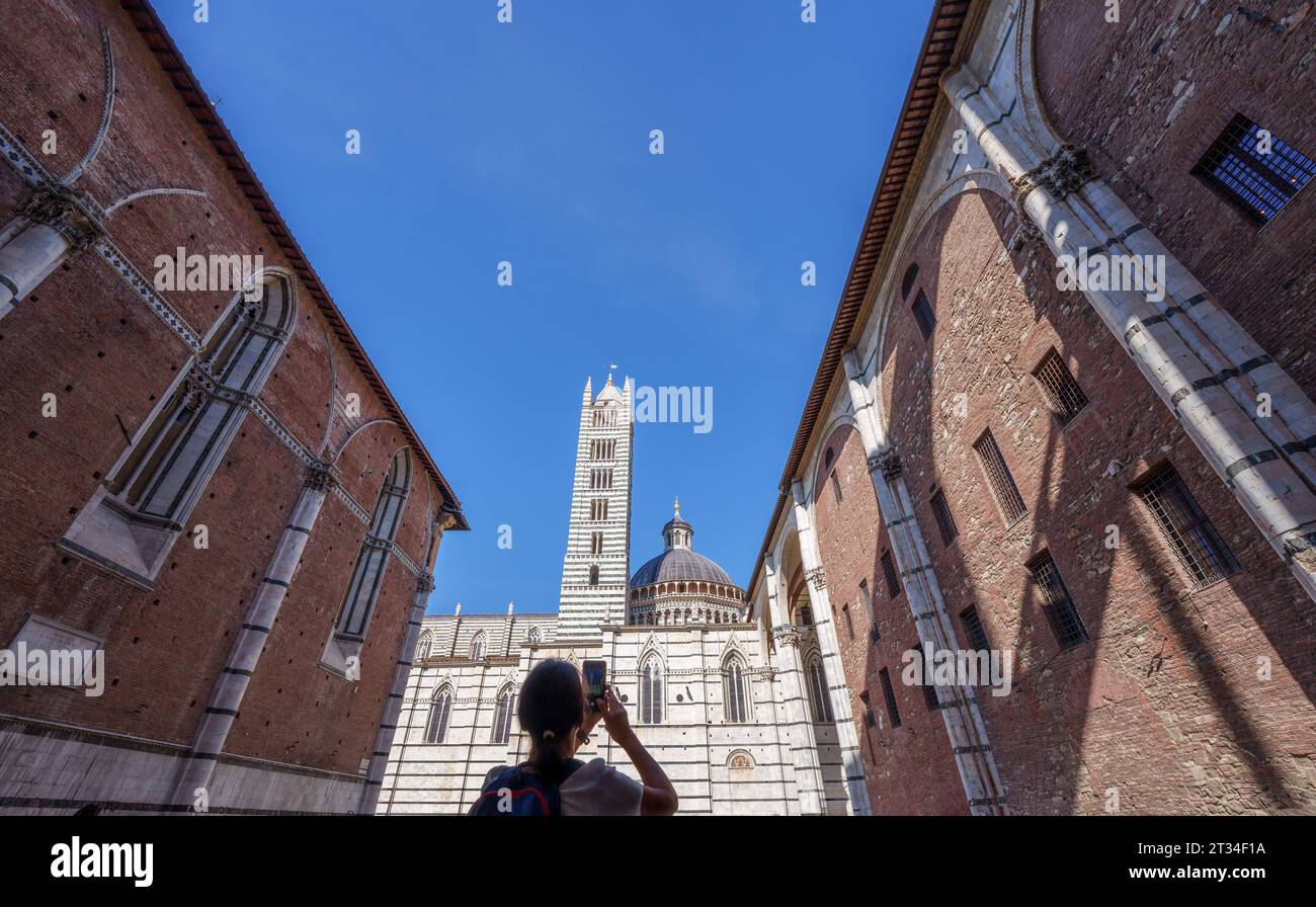 Ein Mädchen, das den Dom von Siena mit ihrem Handy erschießt, in der toskana, Italien Stockfoto