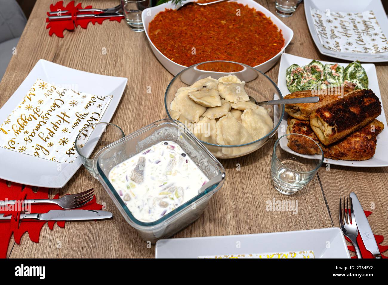 Ein Tisch für das Weihnachtsessen in Polen, sichtbare Teigtaschen, Kroketten und Heringe in Creme. Stockfoto