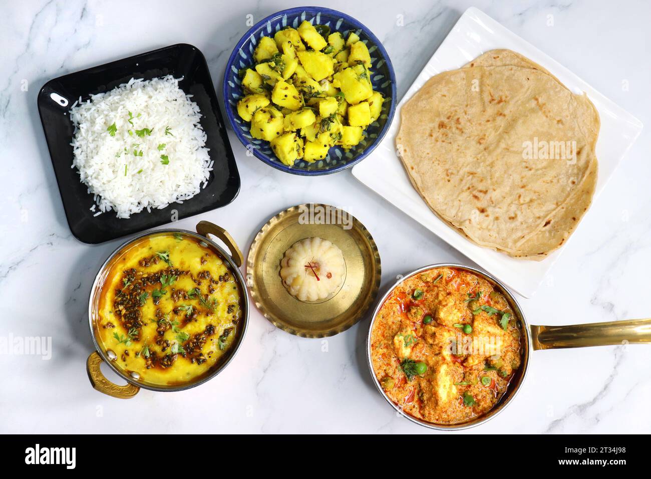 Indische vegetarische Thali oder Platte umfasst Aloo KI Sabji, Dal Reis, Roti Bhaji, Matar Paneer, Sheera oder Suji ka halwa, Chapati. Indisches Essen, sheera. Stockfoto