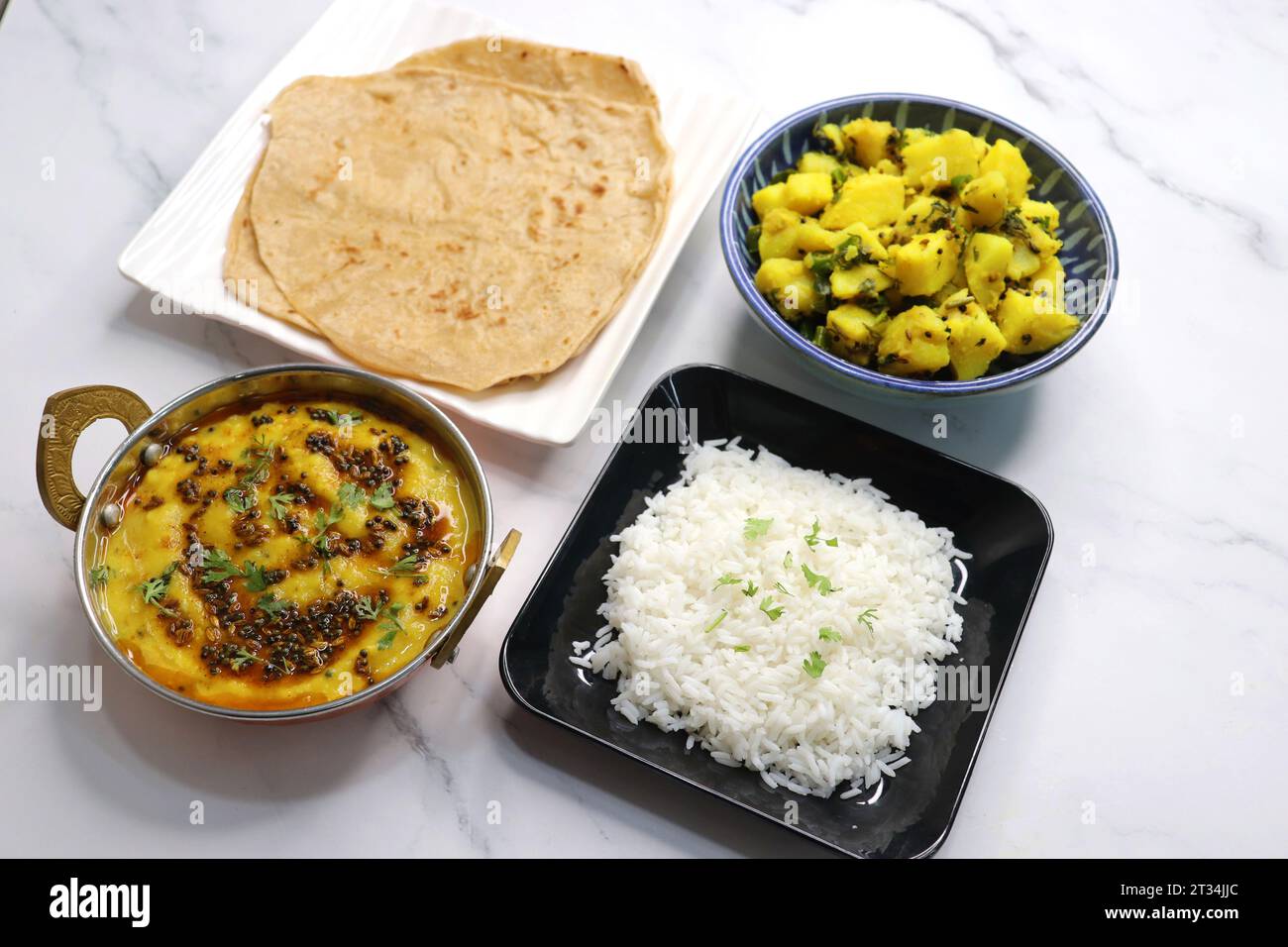 Indische vegetarische Thali oder Platte umfasst Aloo KI Sabji, Dal Reis, Roti Bhaji, Matar Paneer, Sheera oder Suji ka halwa, Chapati. Indisches Essen, sheera. Stockfoto