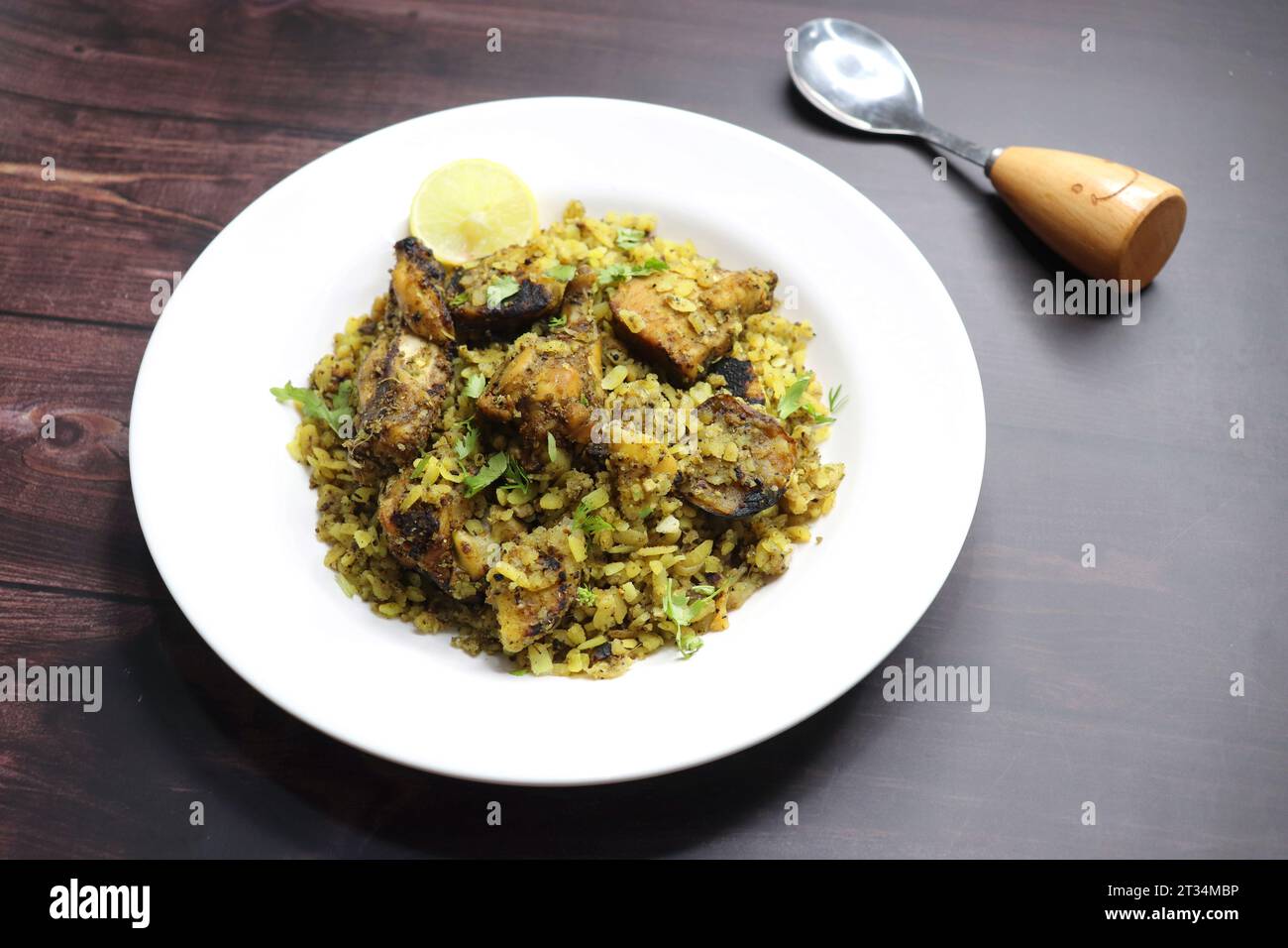 Hühnchen Poha Bhujing ist eine Delikatesse aus Virar, Maharashtra. Es ist ein Holzkohlefeuer, geröstete Hähnchenstücke zusammen mit Kartoffeln, gemischt mit dickem Poha. Stockfoto