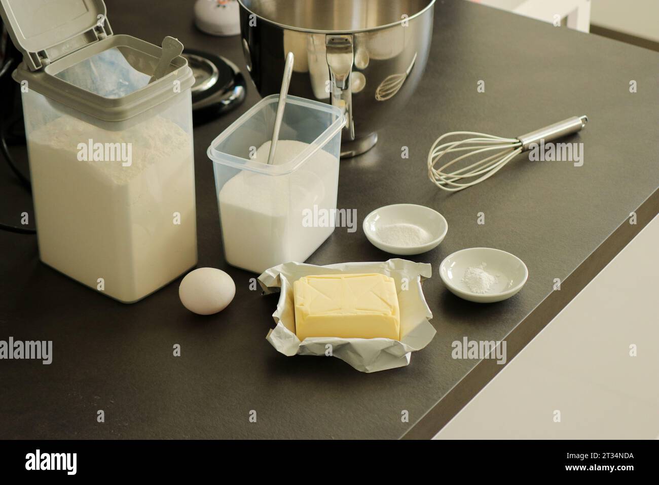 Backteig- oder Tortenzutaten, Mehl, Butter, Ei, Zucker, Backpulver auf grauem Küchentisch Stockfoto