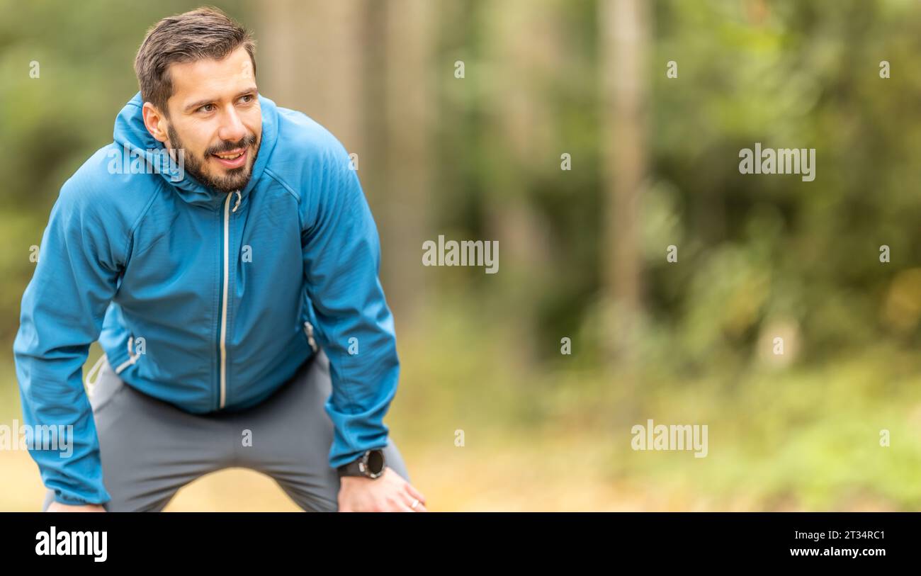 Porträt eines gut aussehenden jungen Athleten in warmer Herbstsportbekleidung. Kopierbereich auf der rechten Seite. Stockfoto