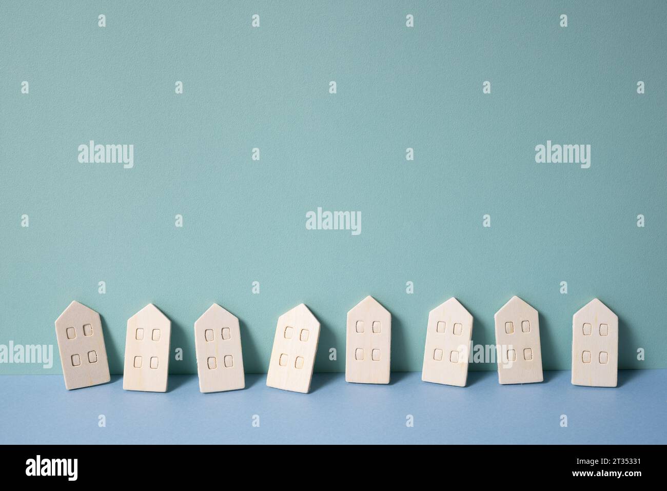 Miniatur-Holzmodellhaus auf mintblauem Hintergrund. Vermietung, Kauf, Immobilienkonzept Stockfoto