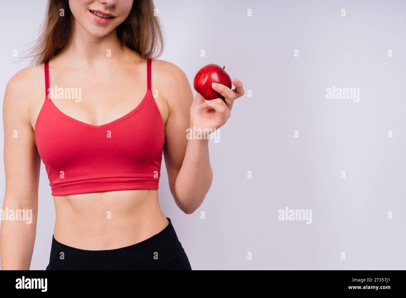 Frühstück am Morgen. Frau mit gesunden Zähnen, die Äpfel auf grauem isoliertem Hintergrund hält. Stockfoto