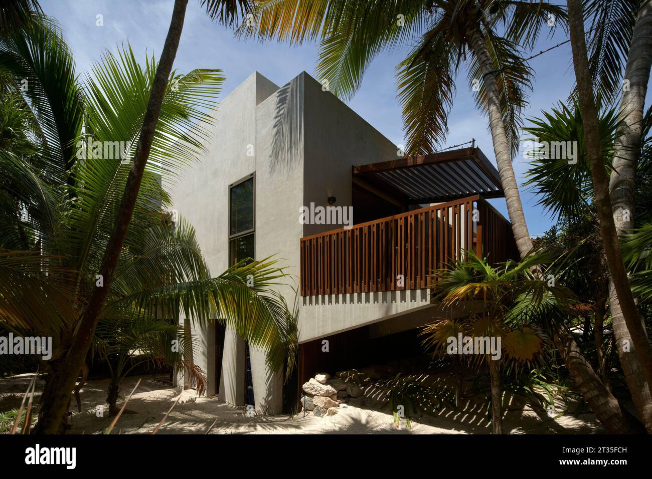Blick auf das Haus durch Bäume. Ferienhaus Tulum - Casa Uh K aay, Tulum, Mexiko. Architekt: Gantous Arquitectos, 2023. Stockfoto