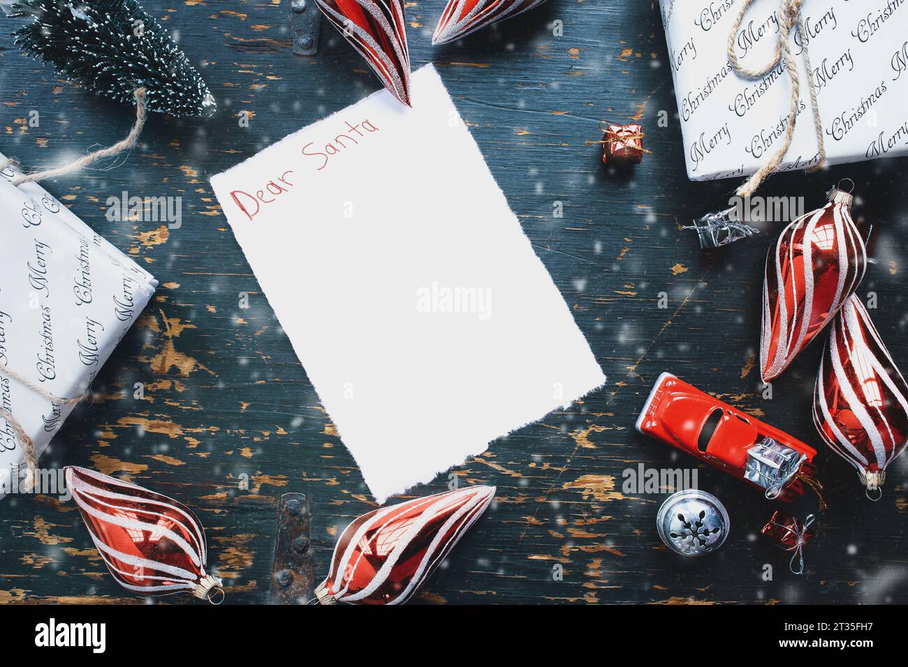 Lieber Weihnachtsmann-Brief, geschrieben mit Buntstiften mit Weihnachtsgeschenken, Ornamenten und Vintage-Spielzeugwagen über rustikalem Hintergrund. Draufsicht von oben. Kopieren Stockfoto