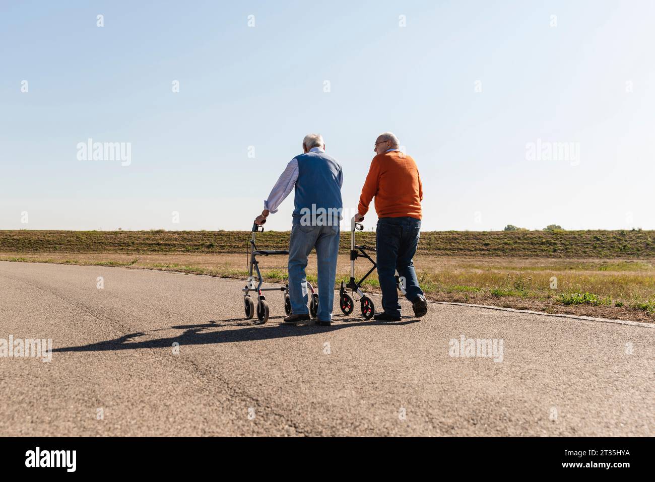 Zwei alte Freunde zu Fuß auf einer Landstraße, mit Rädern, Wanderer Stockfoto