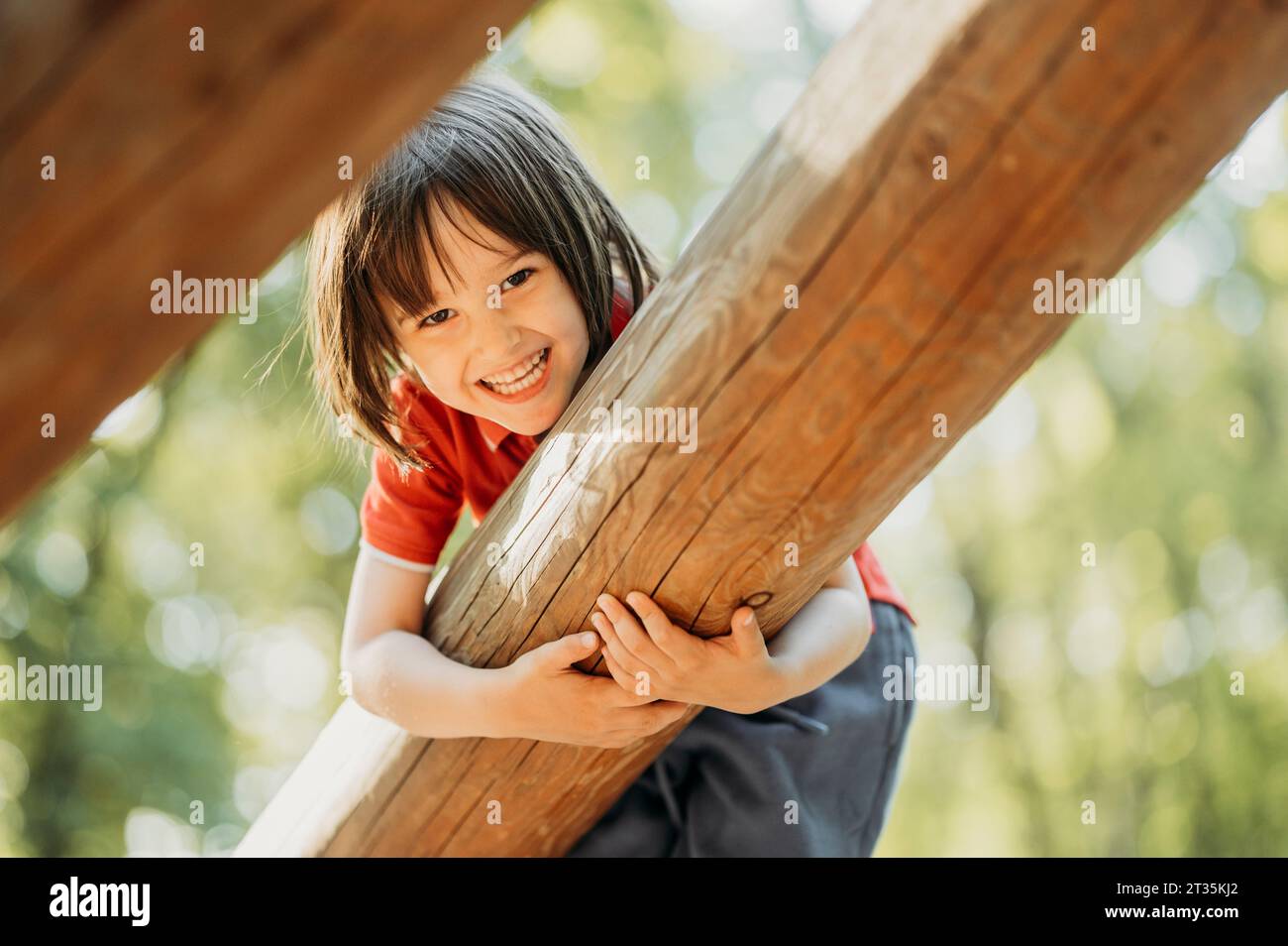 Lächelnder Junge, der auf Holzholz spielt Stockfoto