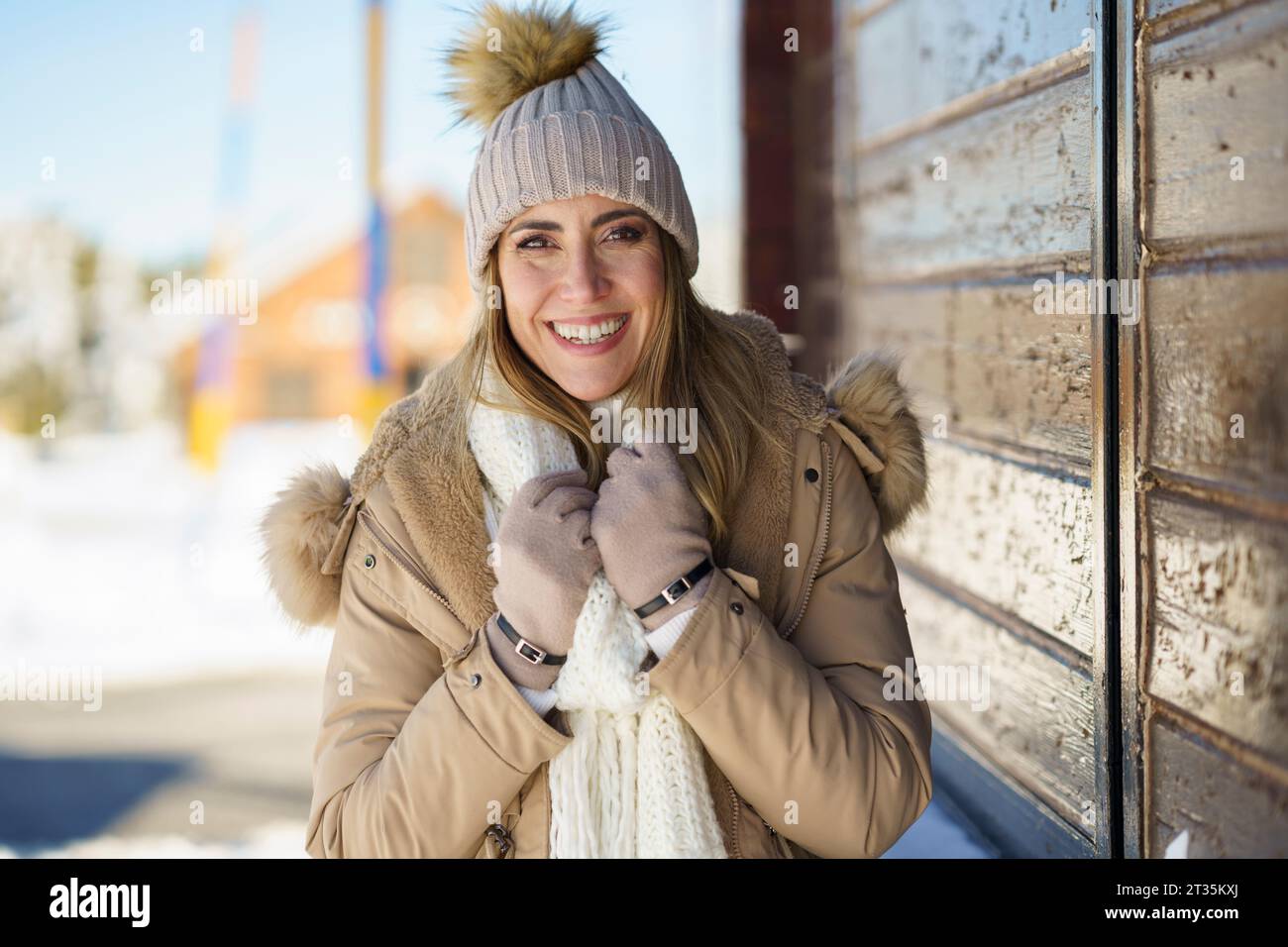 Lächelnde Frau, die sich im Winter kalt fühlt Stockfoto