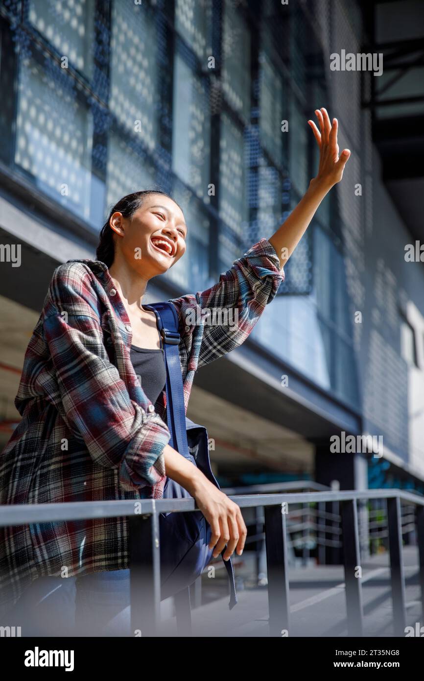 Lächelnder Student, der in der Universität winkt Stockfoto