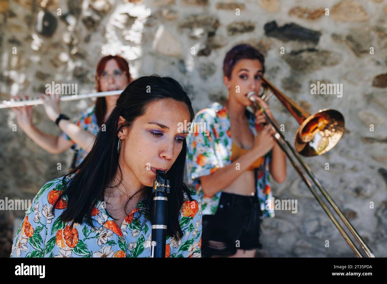 Frau, die Klarinette mit Volksmusikgruppe übt Stockfoto