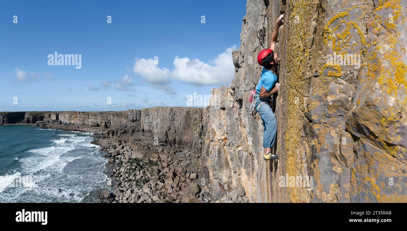 Athlet klettert felsigen Berg an sonnigen Tagen Stockfoto