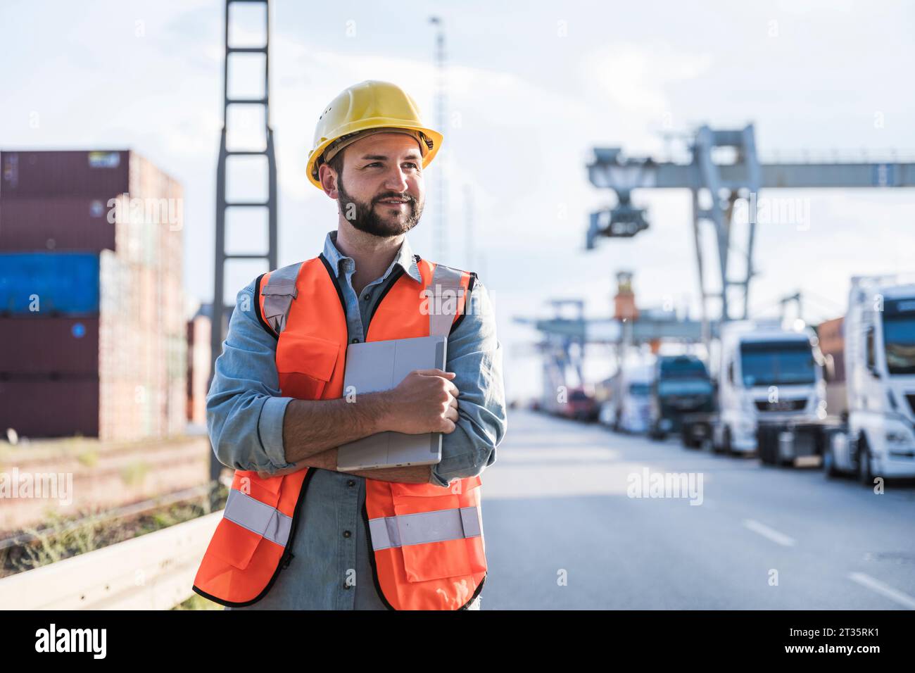 Lächelnder Logistikarbeiter im Industrieviertel Stockfoto