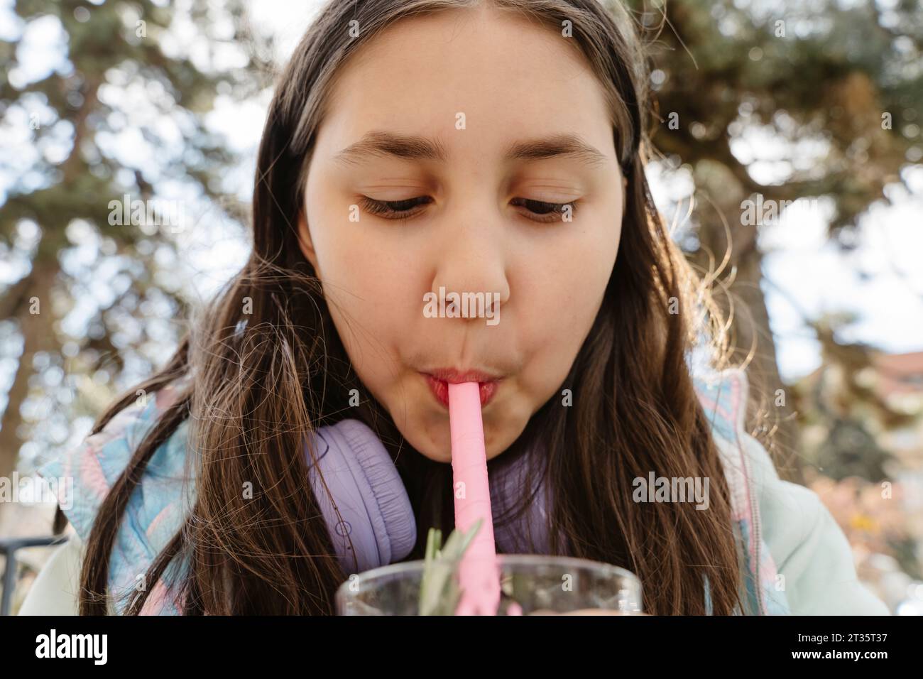 Mädchen schlürft Bubble Tea aus Stroh im Garten Stockfoto