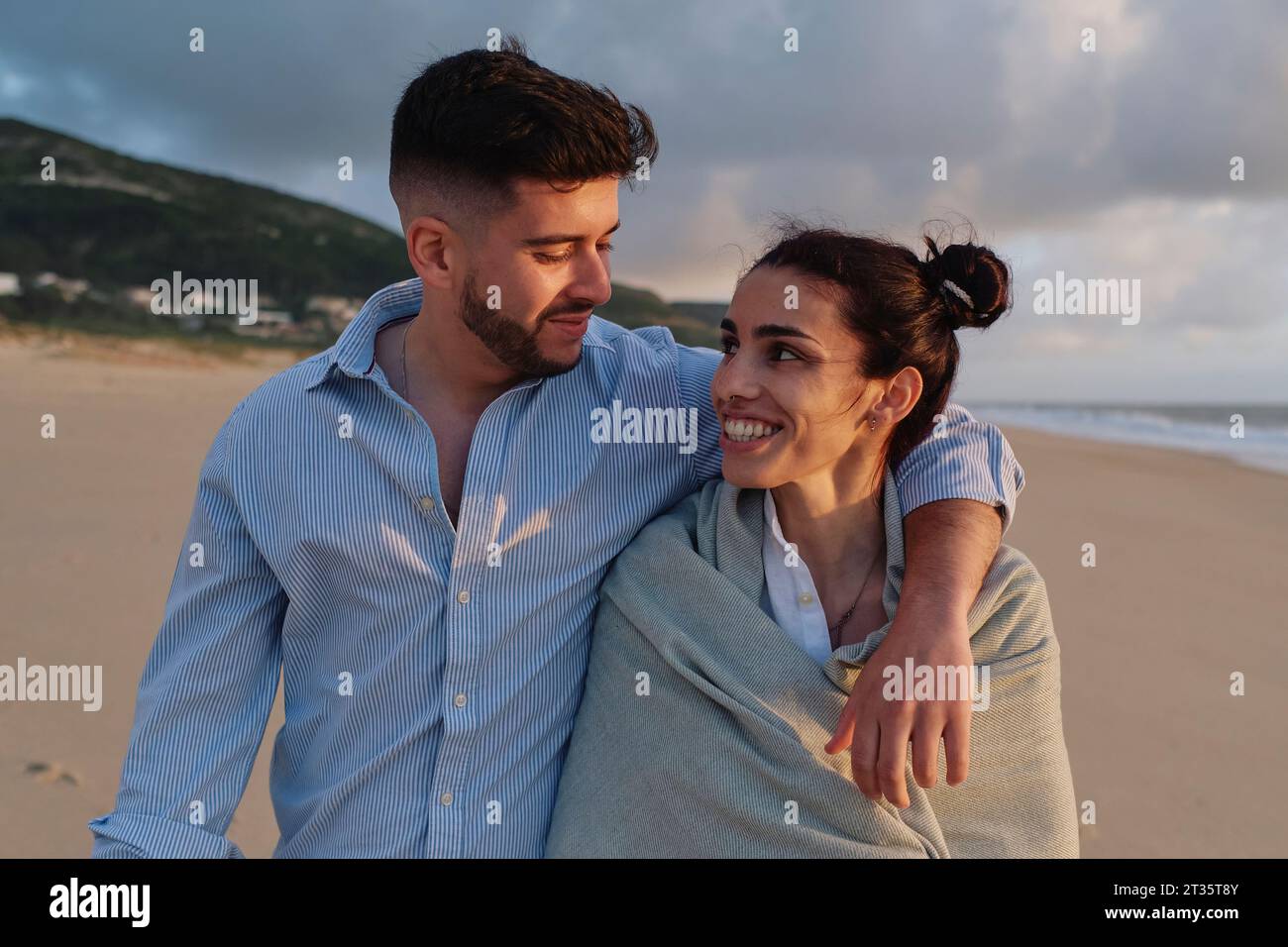 Mann mit Arm um Freundin am Strand Stockfoto