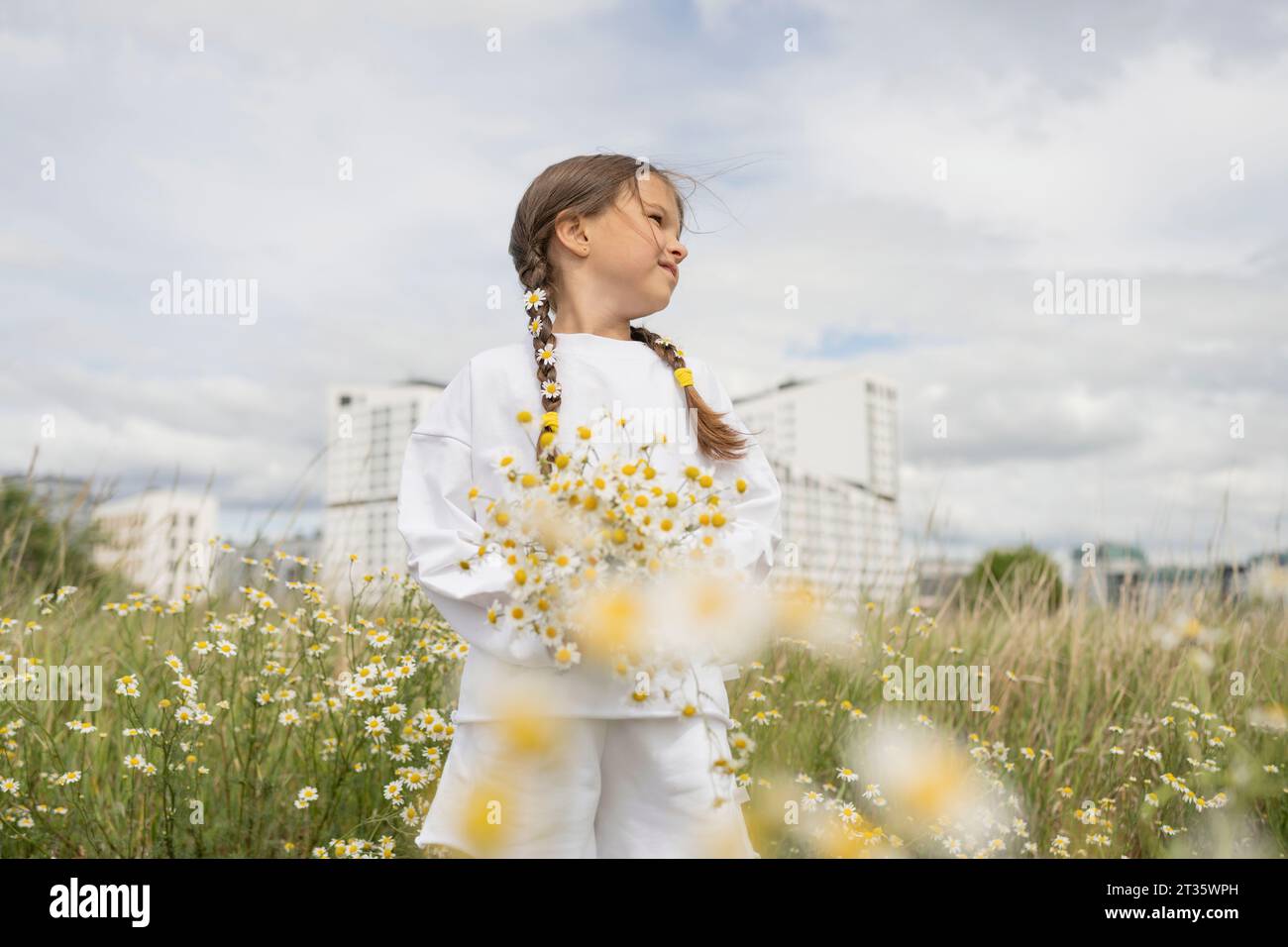 Besinnliches Mädchen mit Blumenstrauß, der inmitten von Pflanzen steht Stockfoto